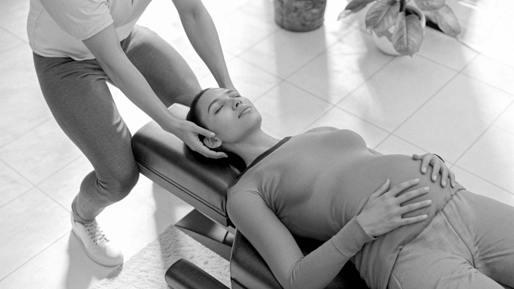 Pregnant woman receiving chiropractic care.