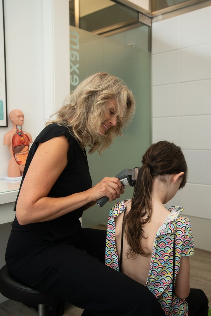 Woman scanning neck of young girl