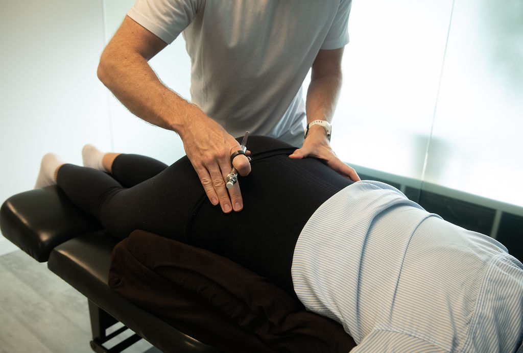 Chiropractor adjusting a maternal prenatal patient's lower back