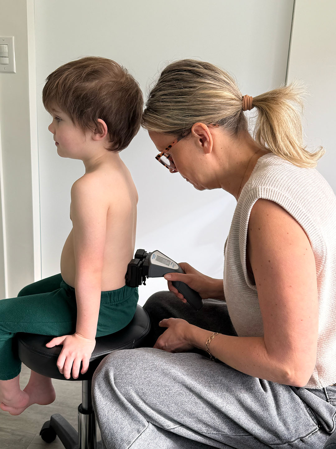 Child sitting, woman scanning back