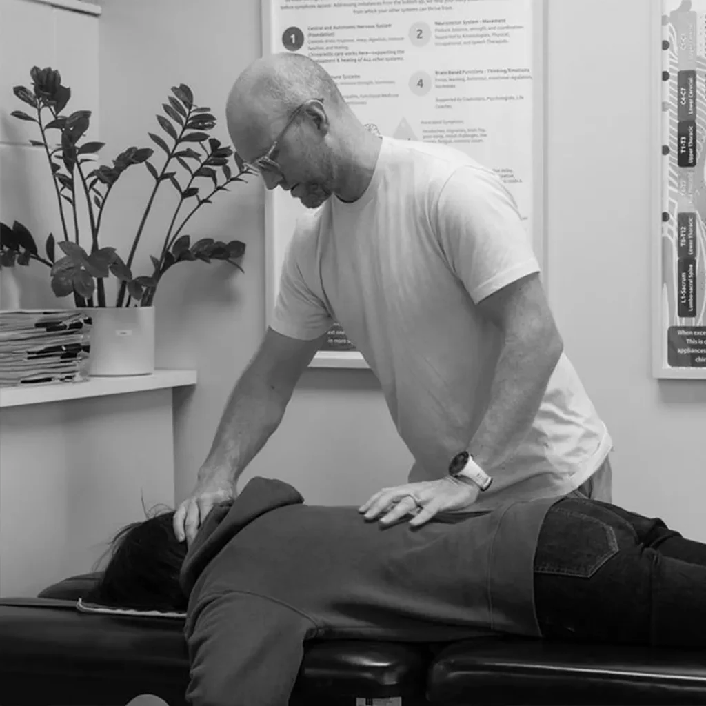 Chiropractor treating patient on table.