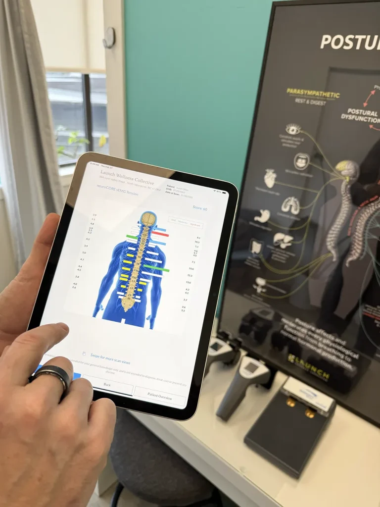 Person using tablet for spinal analysis at a chiropractor office in North Vancouver